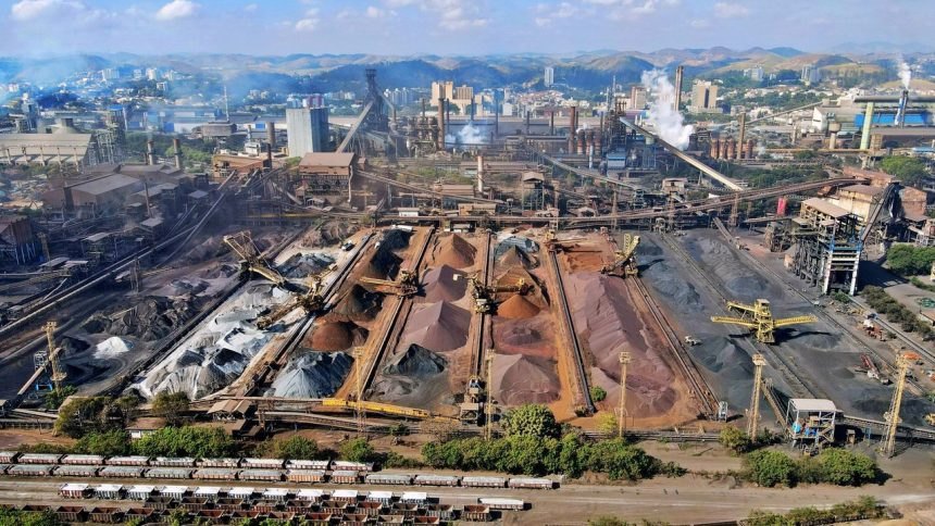 Vista ampla de uma instalação mineradora industrial, com máquinas, estruturas de processamento e pilhas de resíduos minerais.